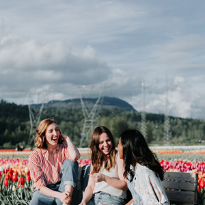 Jeunes filles qui parlent et rient dans un champ de tulipes