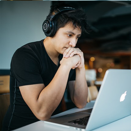 jeune regardant un ordinateur un casque sur les oreilles